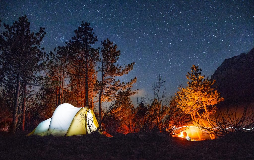A night time camping scene is the main photo for the guide to travel insurance for trips in Canada for Canadians travelling to another country.