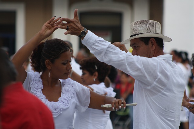 A man and a woman dance in traditional Mexican costumes.